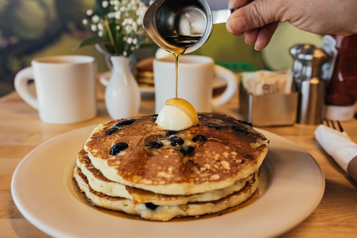 Syrup poured over a stack of blueberry griddle cakes at Matt’s Big Breakfast in Phoenix