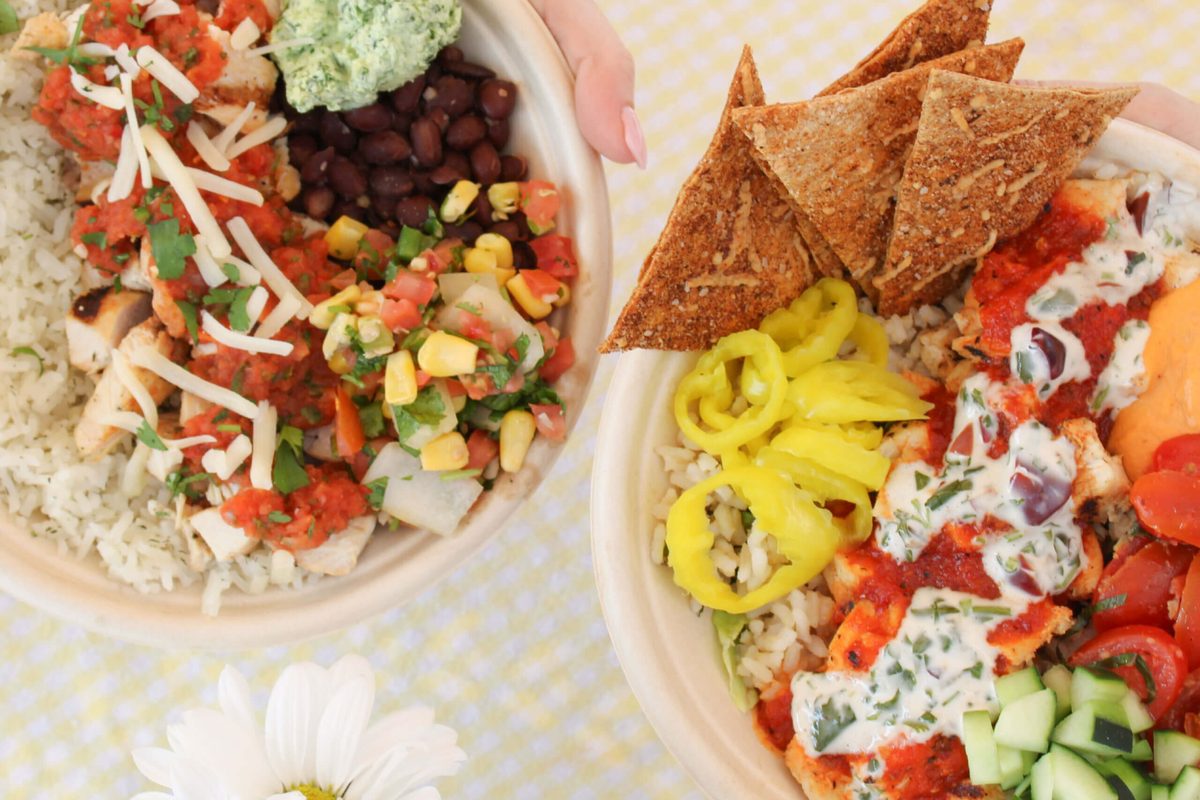 Two colorful protein bowls with rice, salsa, guacamole and pita chips from Original ChopShop