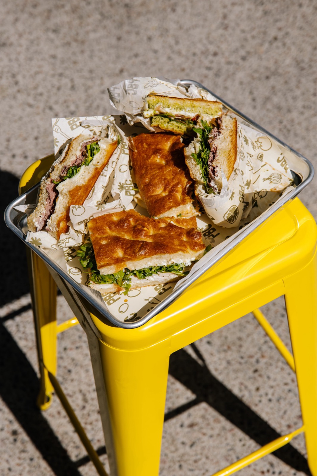 Tray of Paper Bag sandwiches on a yellow stool in the sun